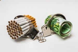 cigarettes-and-money-trapped-in-handcuffs-to-show-the-cost-of-smoking