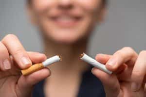 close up of hands breaking a cigarette - break the habit