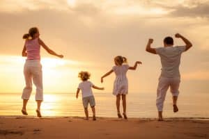 happy-family-jumping-with-joy-on-the-beach-at-sunrise